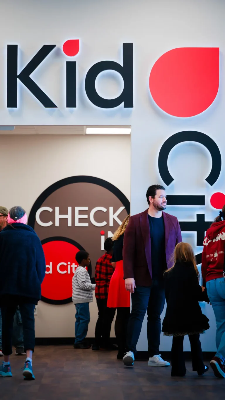 Families standing in front of the Kid City kid's environment entrance