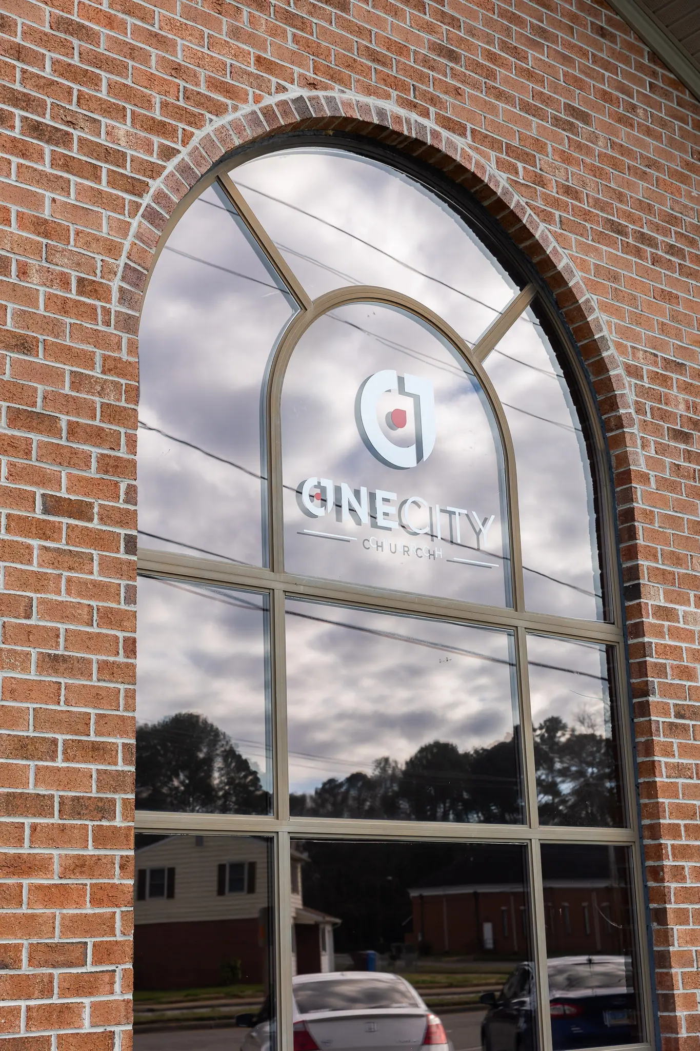 A new One City Church logo decal on the old brick building