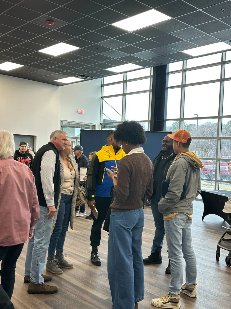 A large group of people talking in a church lobby