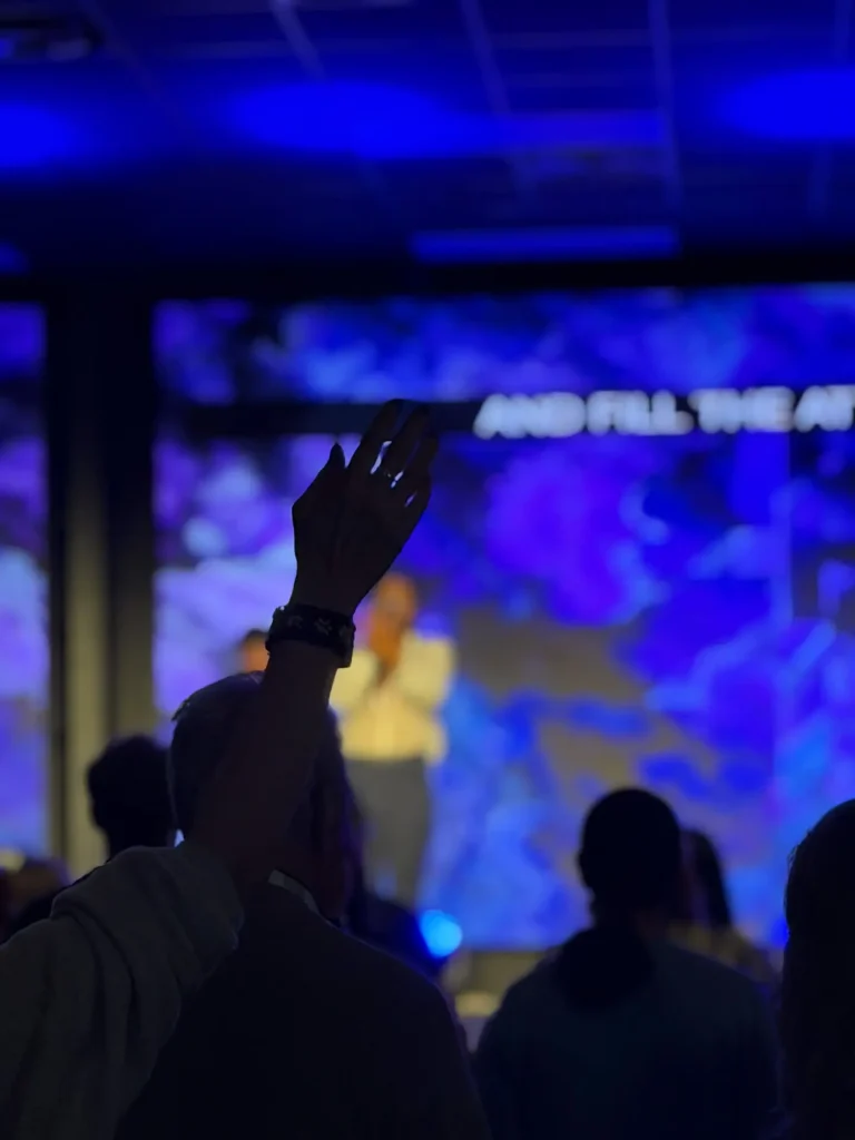 A silhouette of a hand during a dark worship service