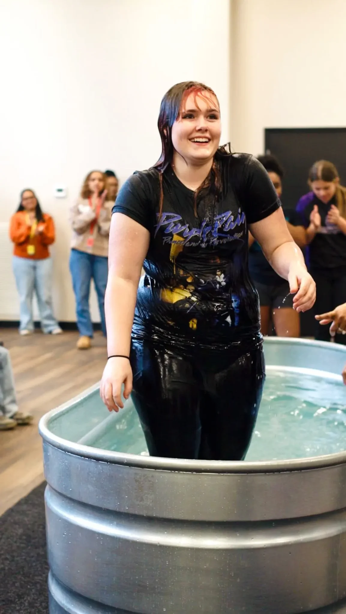 A young woman standing in the baptismal after being baptized