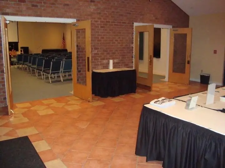 An empty church lobby with an old brick wall and tile flooring