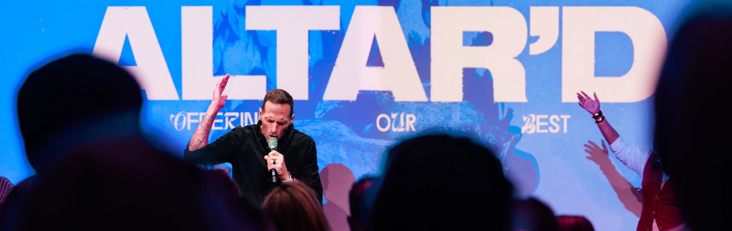 Pastor Jared Fabac preaching in front of a large LED screen